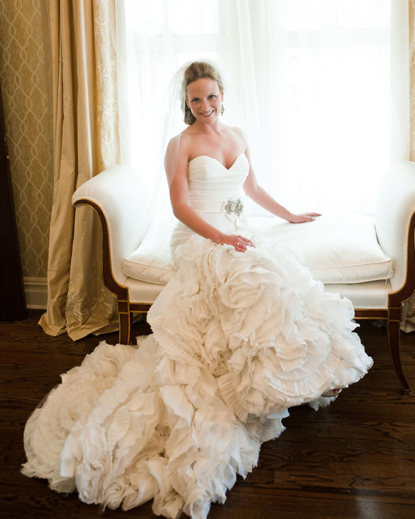Elegant bride in luxury gown seated near a window at the Park Savoy in Florham Park, NJ by Laura Billingham Photography