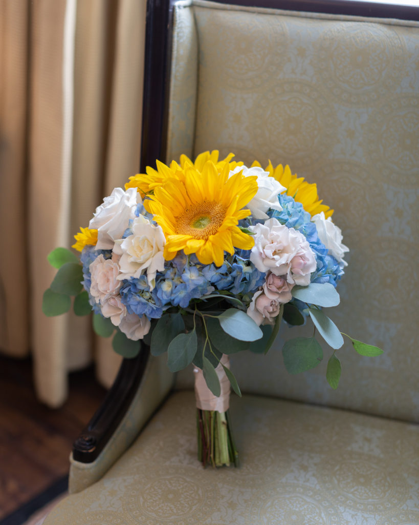 Beautiful bridal bouquet of sunflowers photographed in the bridal suite at the Molly Pitcher Inn in Red Bank, NJ by Laura Billingham