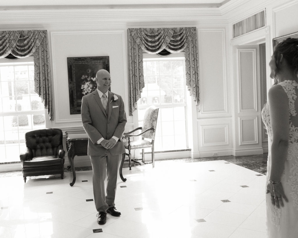 Bride and groom enjoy a first look in the lobby of the Molly Pitcher Inn in Red Bank, NJ photographed by Laura Billingham