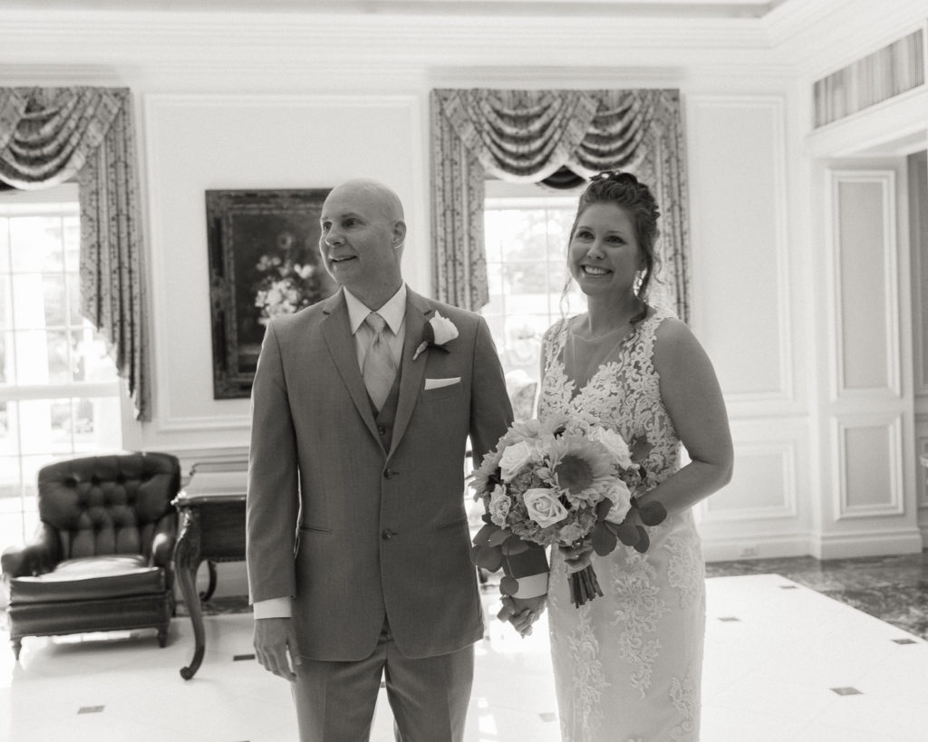 Bride and groom enjoy a first look in the lobby of the Molly Pitcher Inn in Red Bank, NJ photographed by Laura Billingham