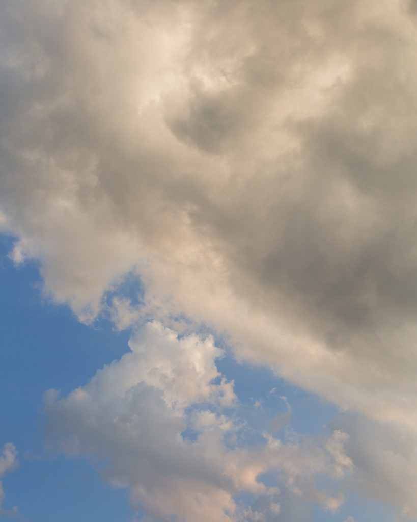 Fluffy clouds in a blue sky before sunset at an elegant wedding at Molly Pitcher Inn in Red Bank, NJ photographed by Laura Billingham