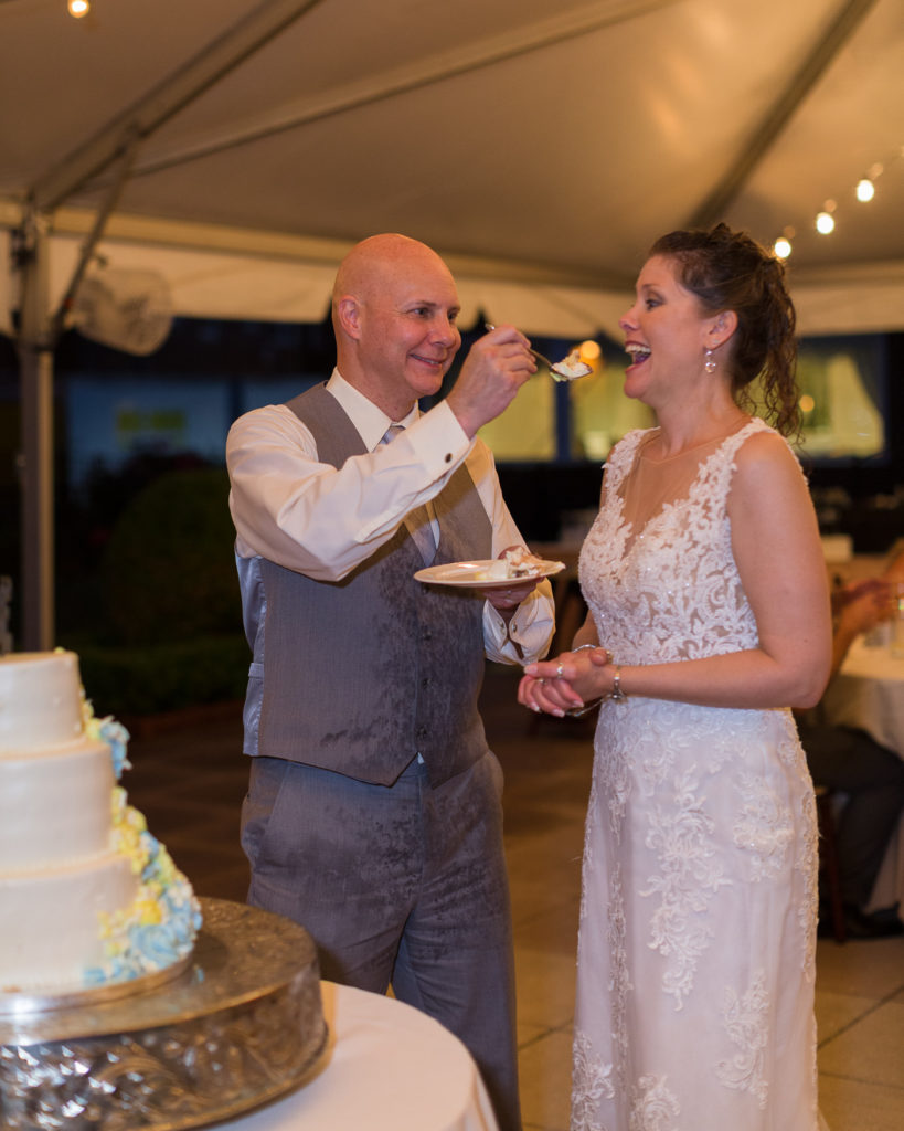 Bride and groom cut their cake under the tent at the Molly Pitcher Inn in Red Bank, NJ by wedding photographer Laura Billingham