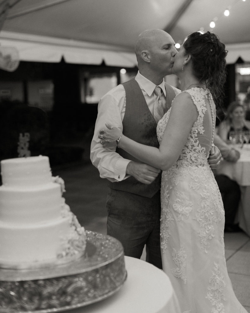 Bride and groom cut their cake under the tent at the Molly Pitcher Inn in Red Bank, NJ by wedding photographer Laura Billingham