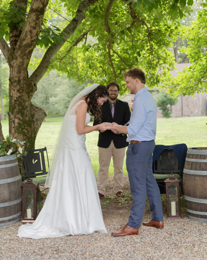 bride and groom share a laugh during their ceremony at the Woolverton Inn, wedding photography by Laura Billingham