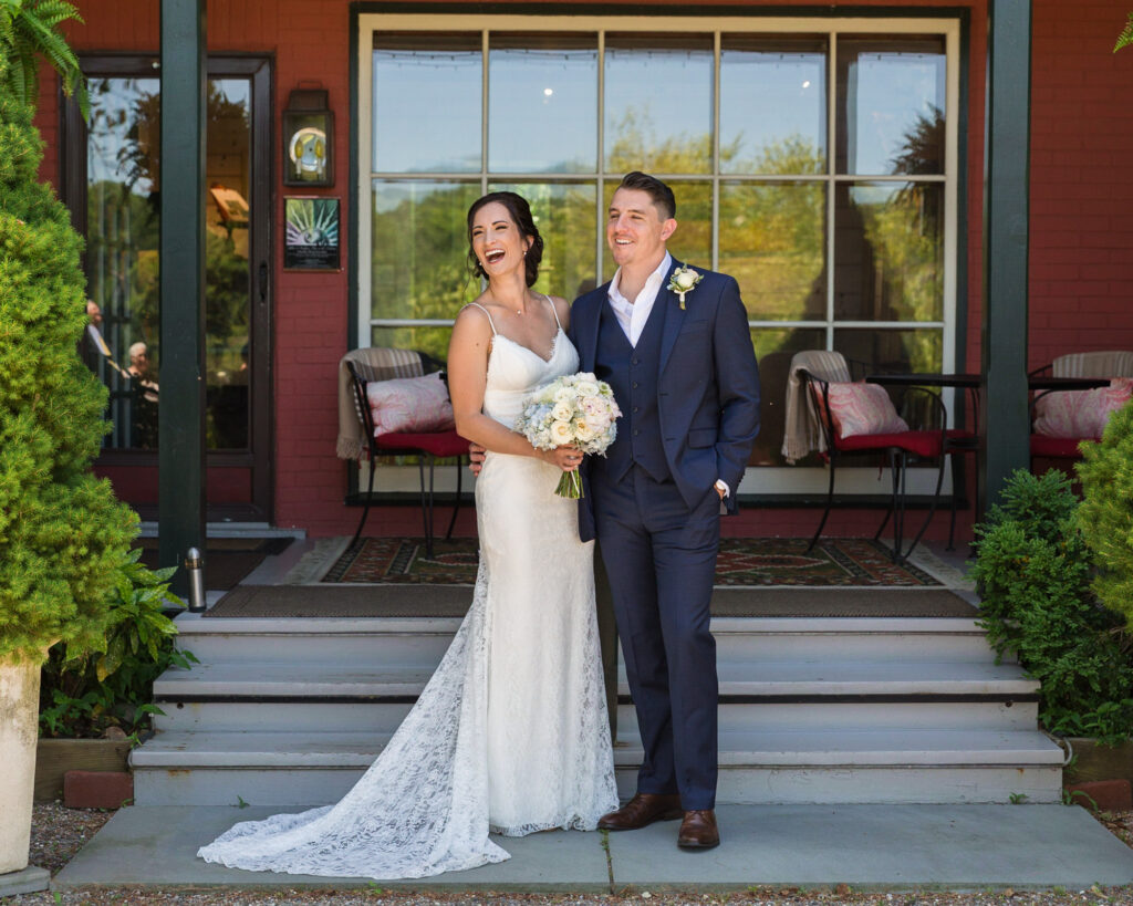 Candid portrait of an elegant bridge and groom in front of Bridgeton House on the Delaware photograph by Laura Billingham Photography