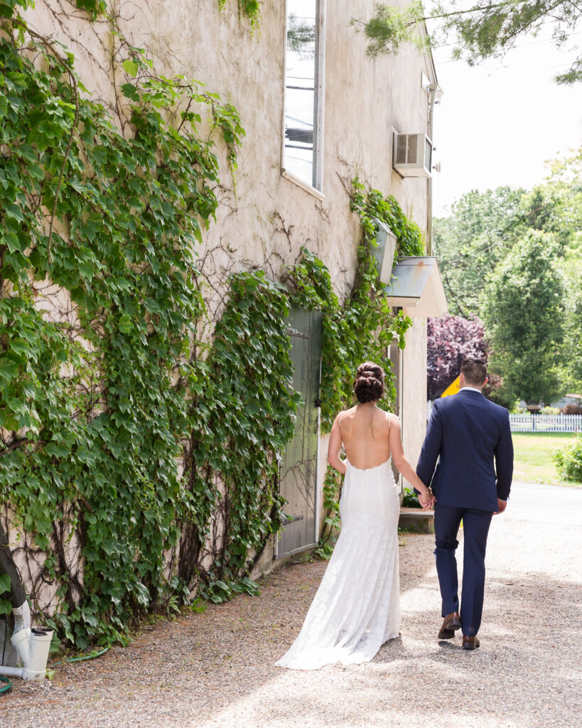 An elegant bride and groom walking away next to Bridgeton House on the Delaware by Laura Billingham Photography