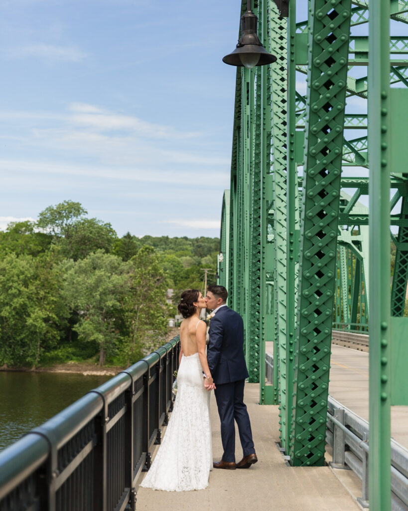 Elegant bride and groom kissing on the Milford, NJ bridge near Bridgeton House on the Delaware by Laura Billingham Photography