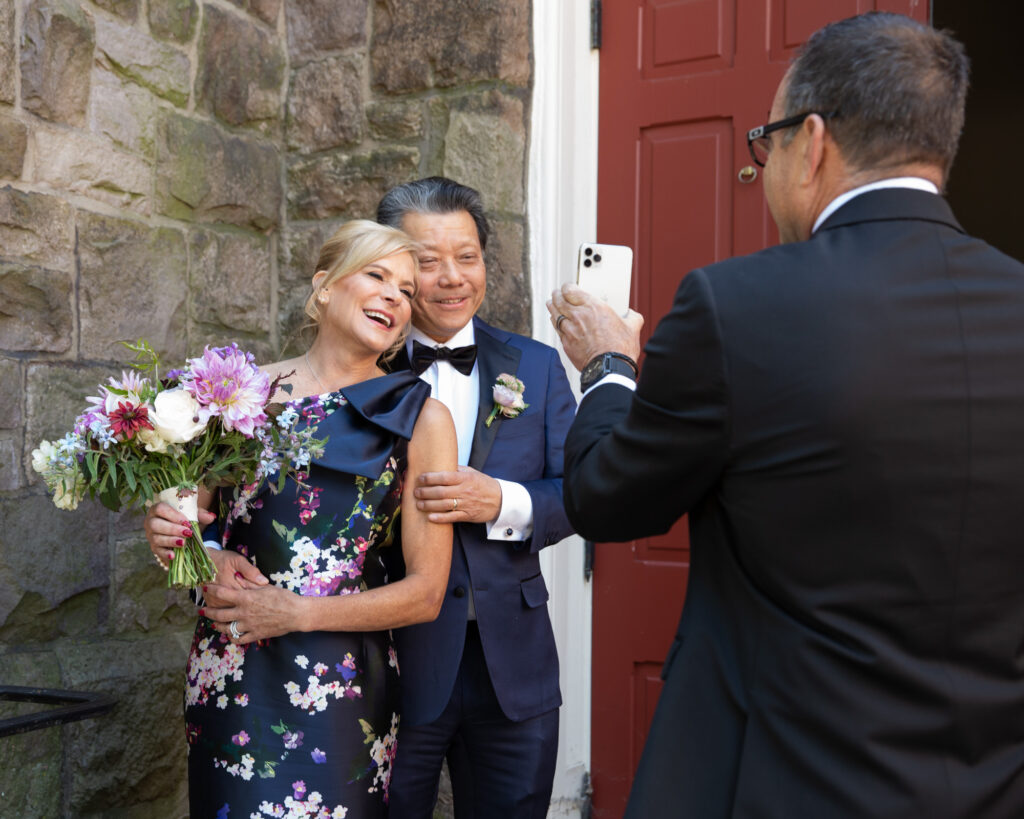 Elegant bride and groom make video call to family after saying vows at Flemington Presbyterian Church in Flemington NJ photographed by Laura Billingham