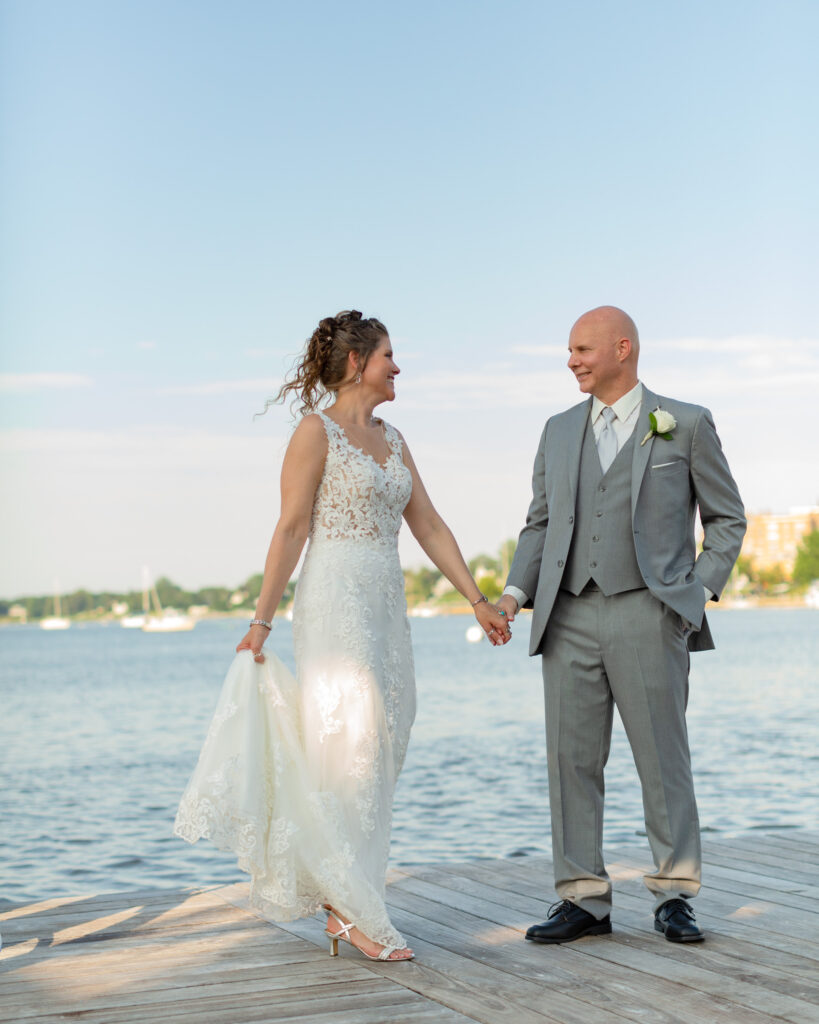 Bride and groom holding hands after summer outdoor wedding ceremony at the Molly Pitcher Inn in Red Bank, NJ photographed by Laura Billingham