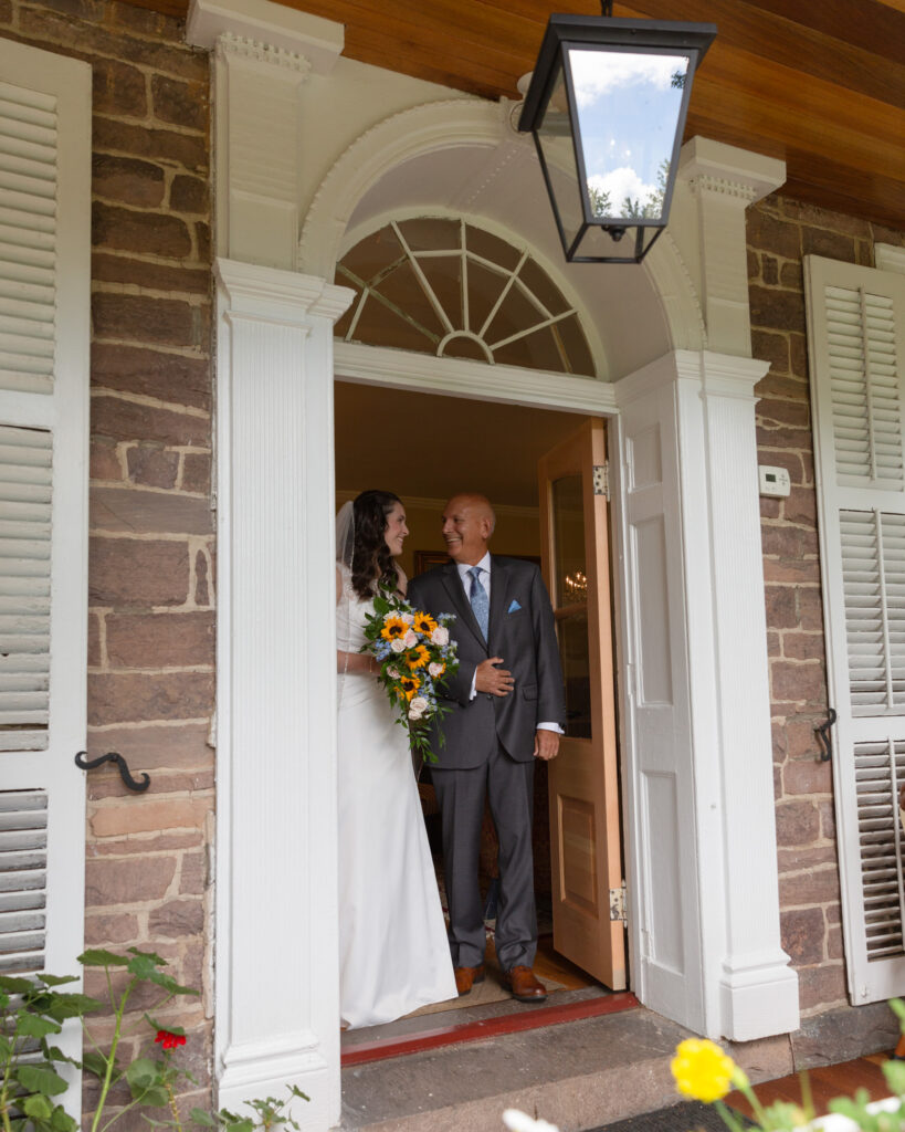 Bride and her father in a doorway at the Woolverton Inn in Stockton, NJ just before walking down the aisle photographed by Laura Billingham