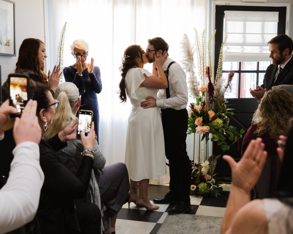 Bride and groom share first kiss after their micro wedding ceremony at 15 Landsdowne in Frenchtown, NJ photographed by Laura Billingham