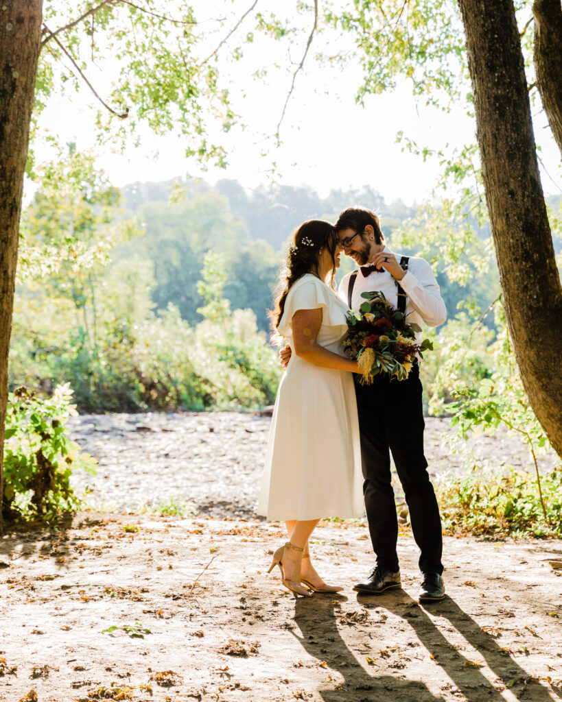 Bride and groom by the Delaware River after their micro wedding at 15 Landsdowne in Frenchtown, NJ photographed by Laura Billingham