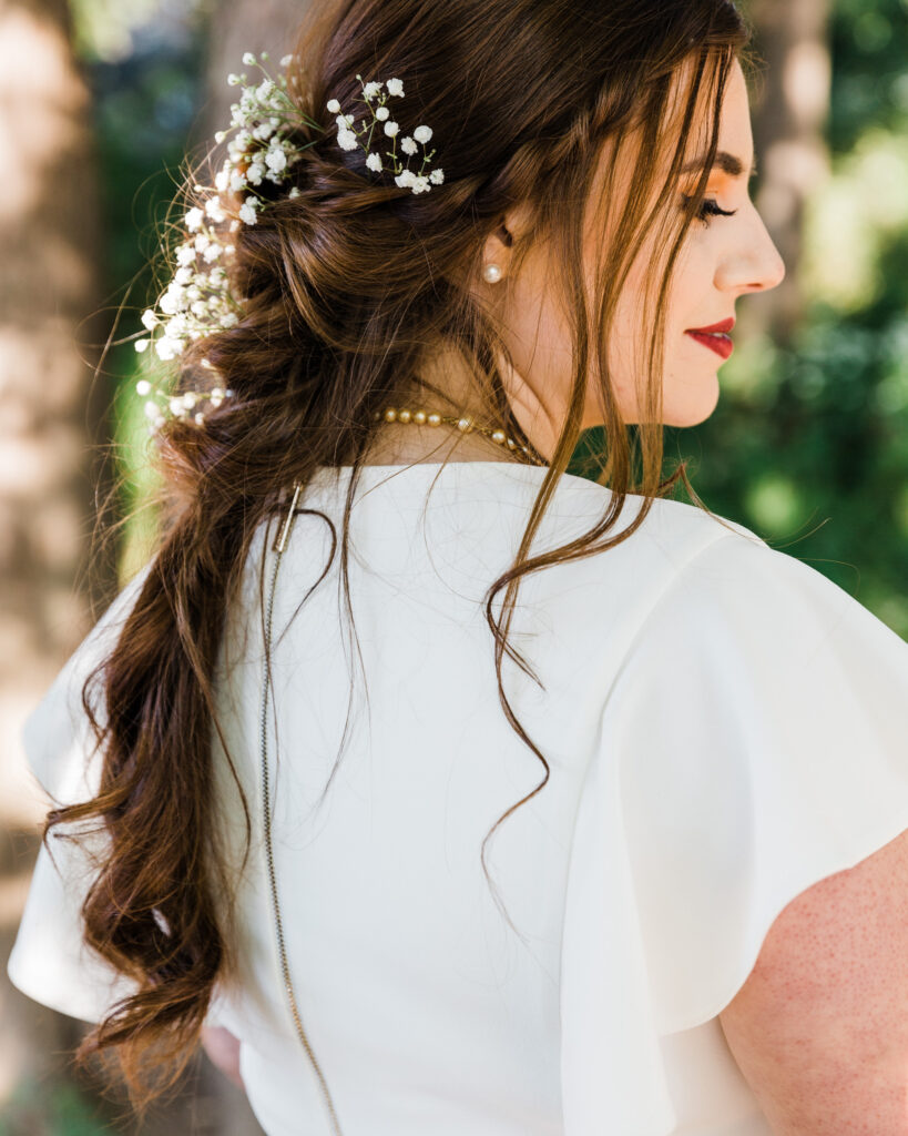 Detail of a bride's hair braid with baby's breath by the Delaware River after micro wedding at 15 Landsdowne in Frenchtown, NJ photographed by Laura Billingham