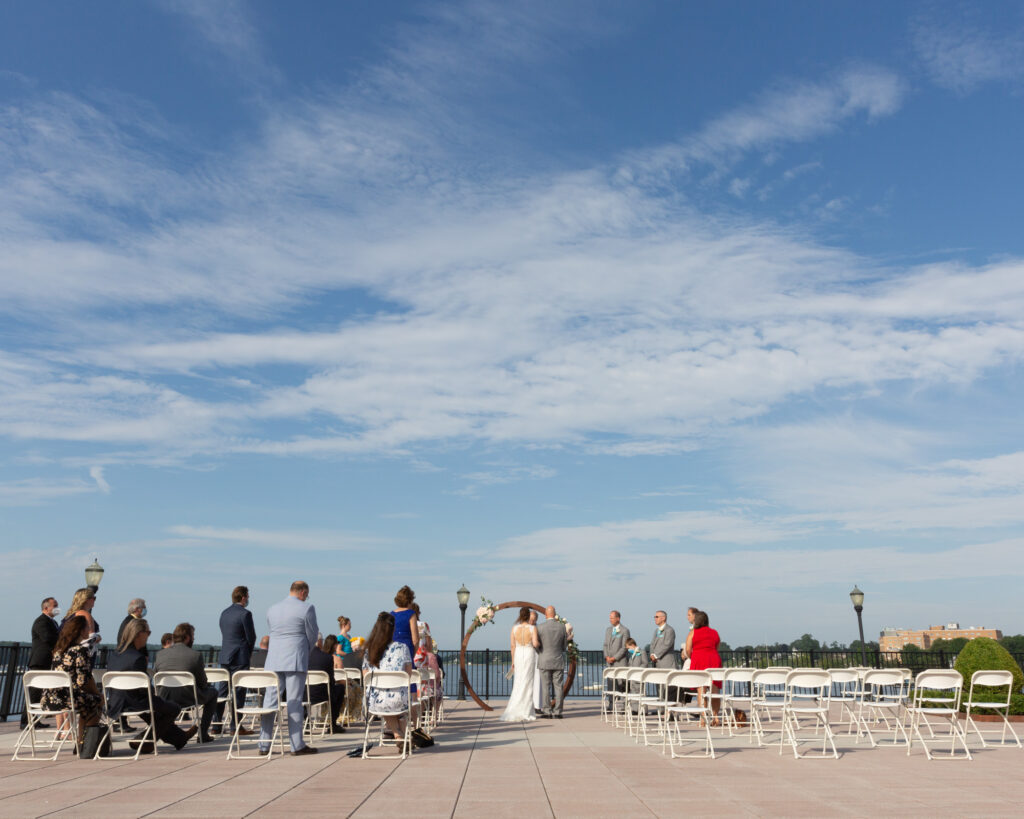 Bride and groom say their vows during a summer outdoor wedding ceremony at the Molly Pitcher Inn in Red Bank, NJ photographed by Laura Billingham