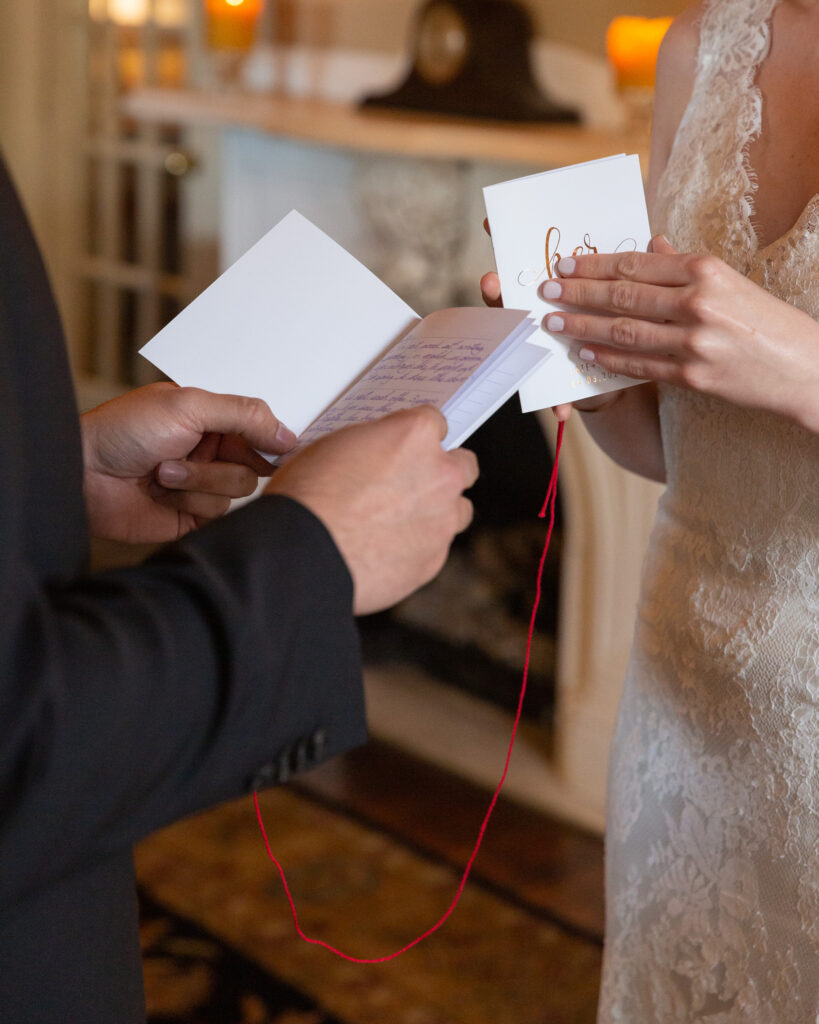 Detail photo of a bride and groom opening their vows books during their wedding ceremony 
