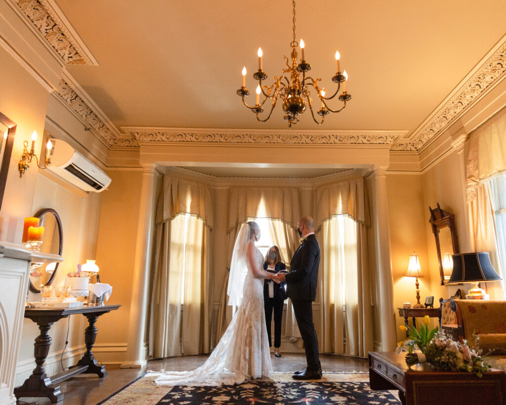 Bride and groom say their vows in the elegant historic Sayre Mansion during an elopement ceremony in the parlor of the historic Sayre Mansion
