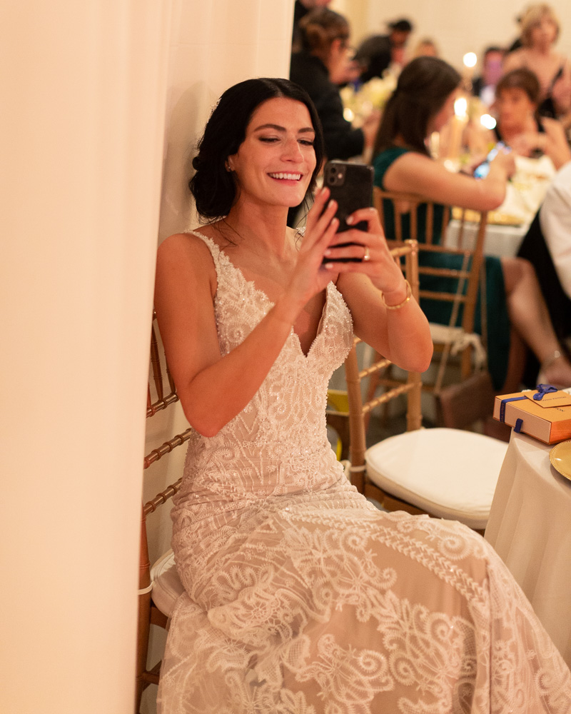 Elegant bride takes a photo on her phone at her wedding reception at the Bernards Inn in Bernardsville NJ