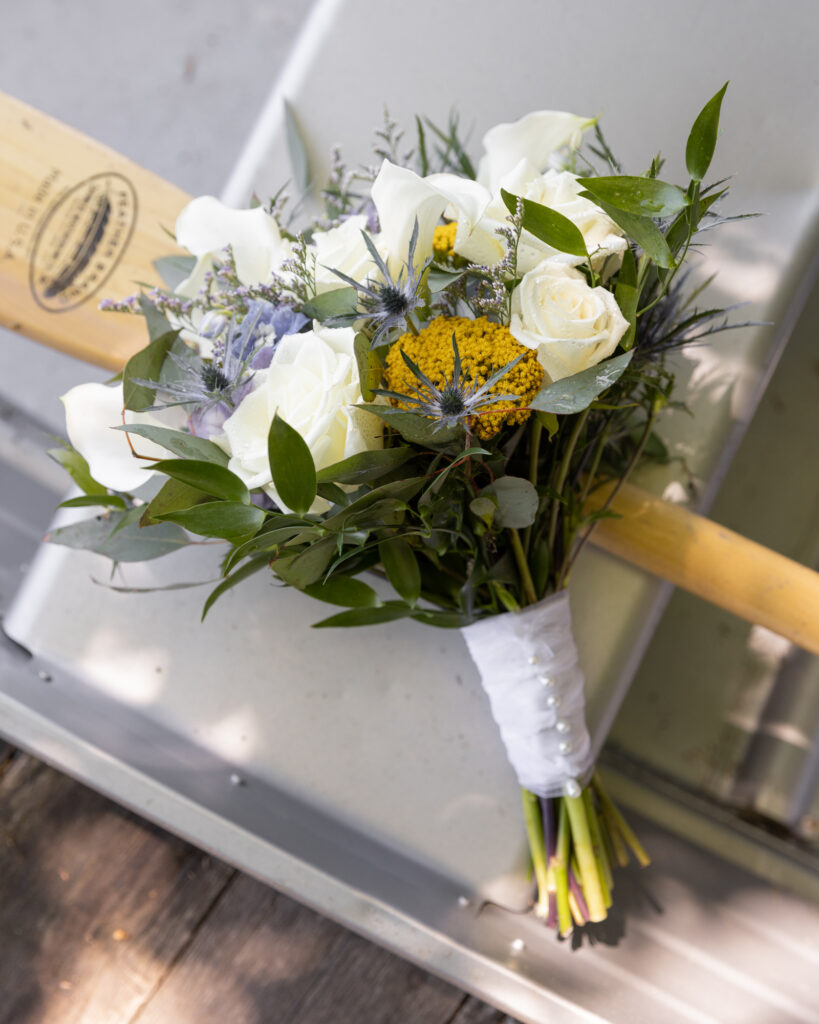 elegant wedding bouquet on a paddle in a rowboat at the Lodge at Mountain Springs Lake Resort in Reeders, PA