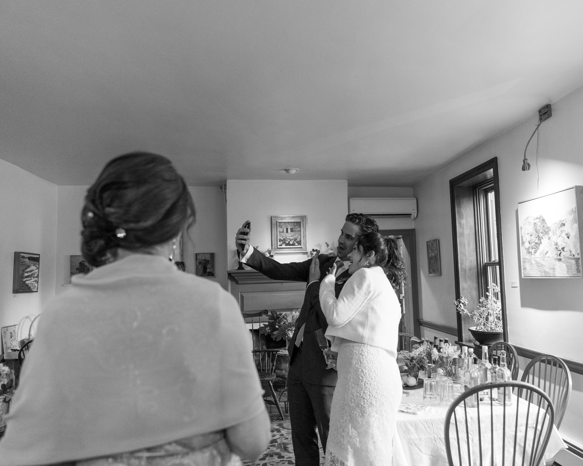 black and white photo of a stylish bride and room taking a selfie just after their wedding at Bridgeton House on the Delaware in Bucks County, PA