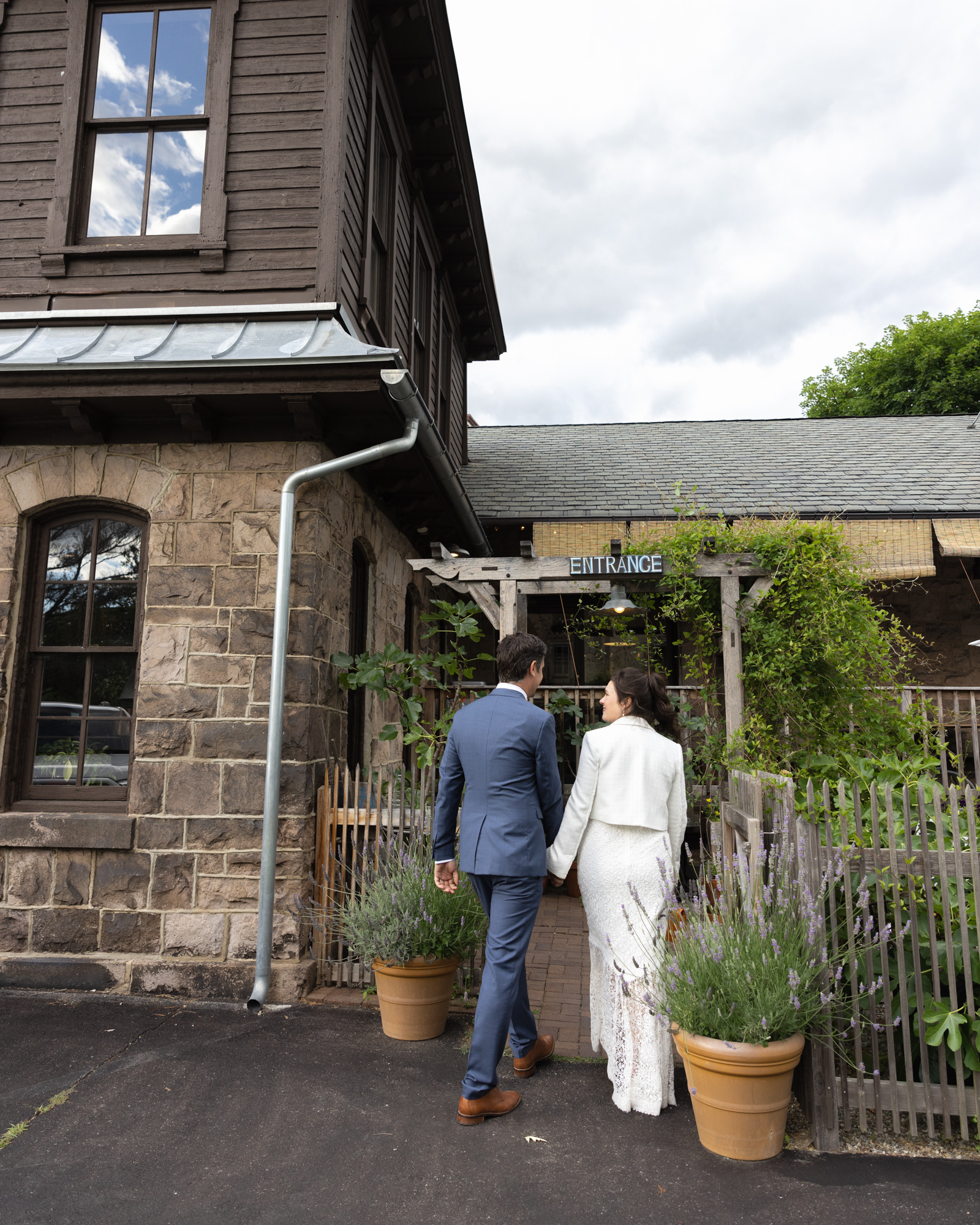 Elegant bride and groom enter for their wedding reception via the garden gate at Canal House Station restaurant 