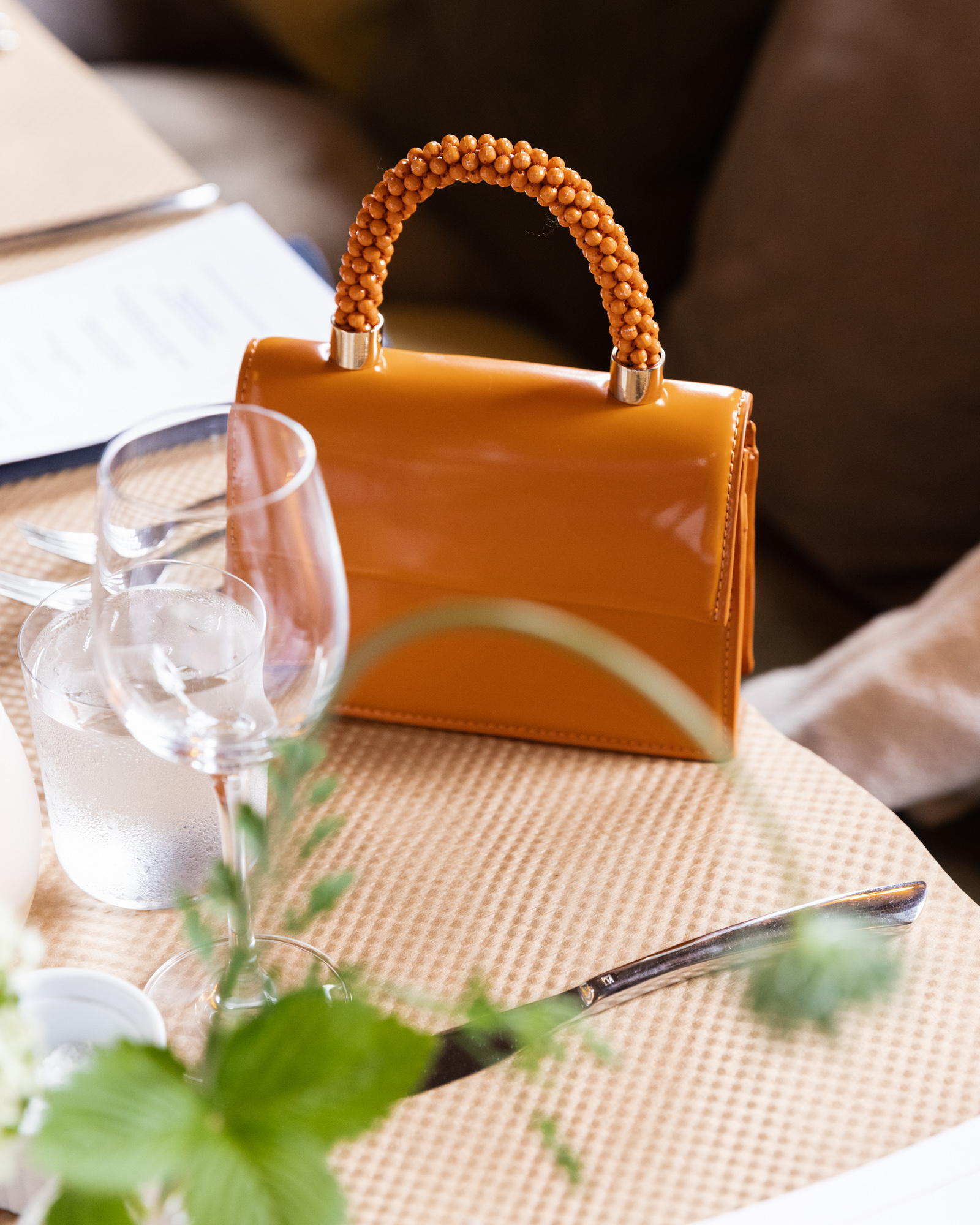 Bride's stylish orange purse sits atop an elegant wedding reception table at Canal House Station in Milford, NJ