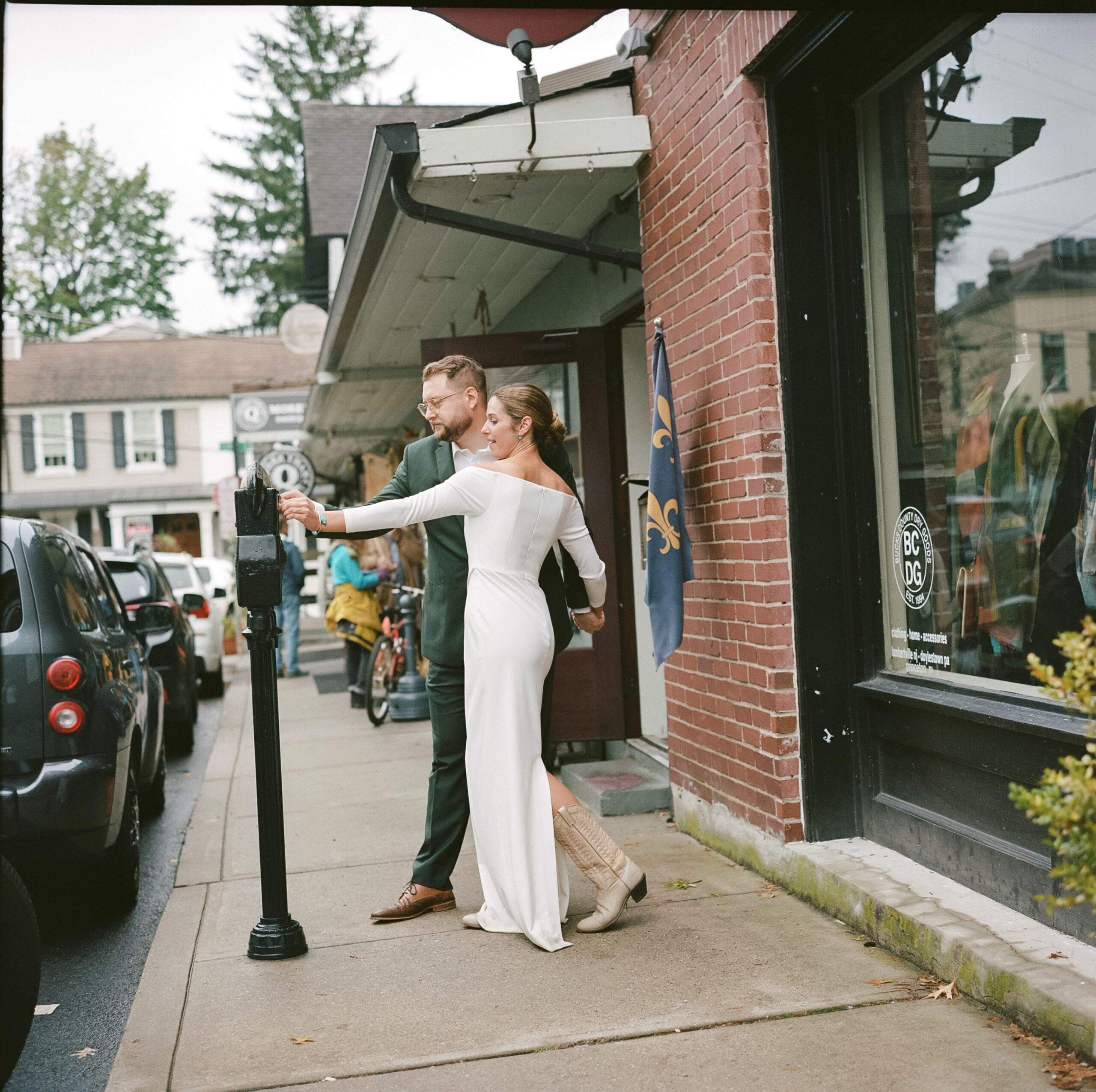 Color photo on medim format film of an elegant Bride playfully checking her parking meter outside Brian's restaurant in Lambertville, NJ