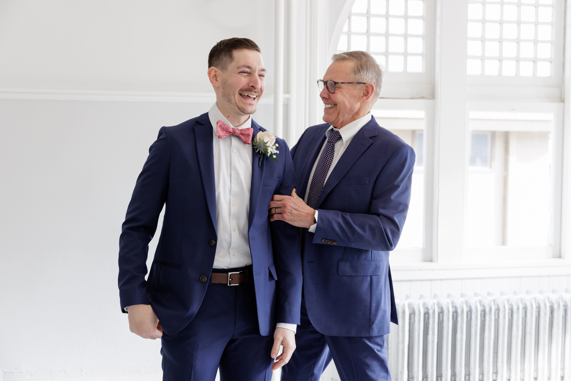 Groom and father in law laugh during a portrait session at a wedding at Old City Hall in Bordentown, NJ