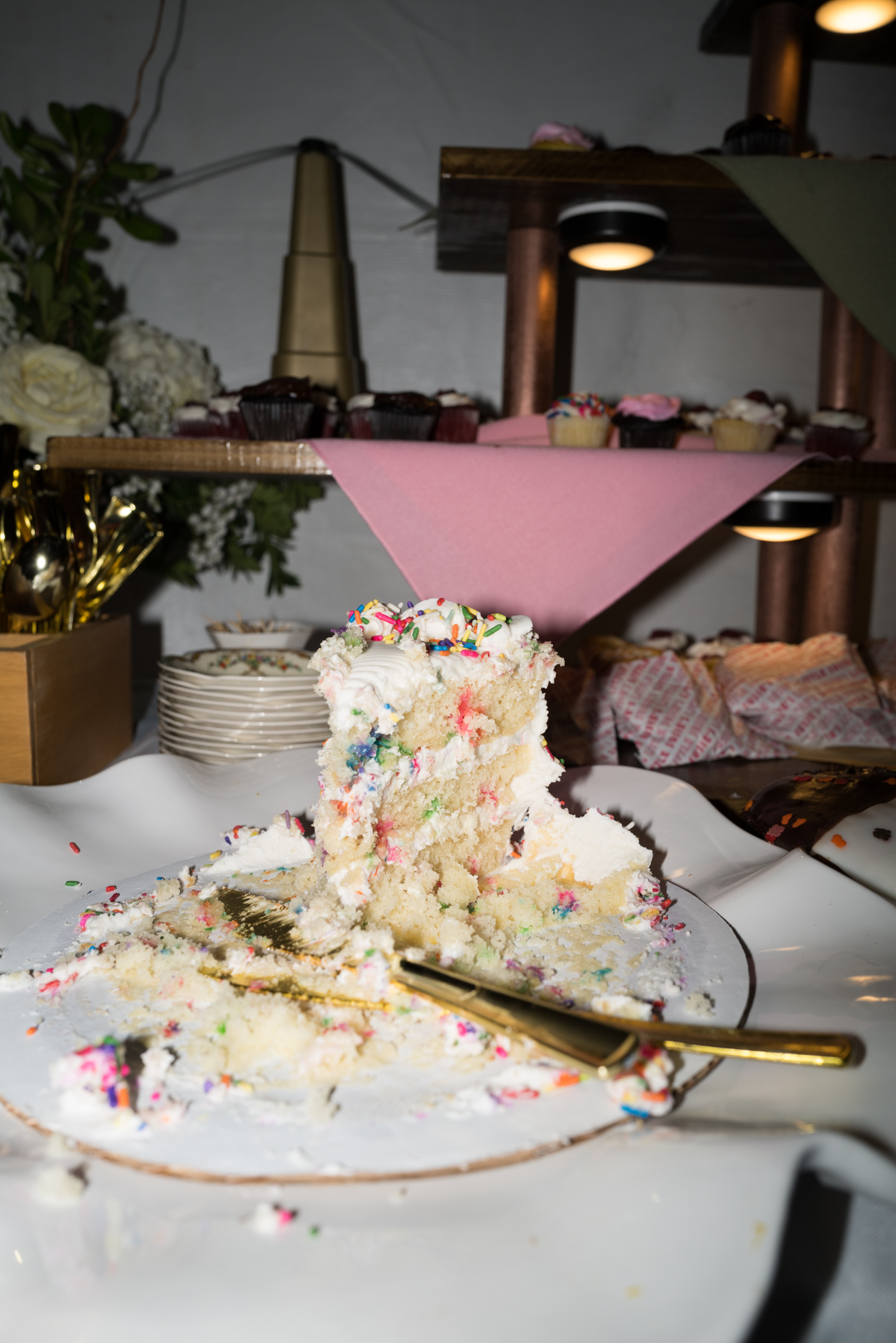 a messy, colorful slice of three teired confetti cake at the end of an at home wedding reception in New Jersey