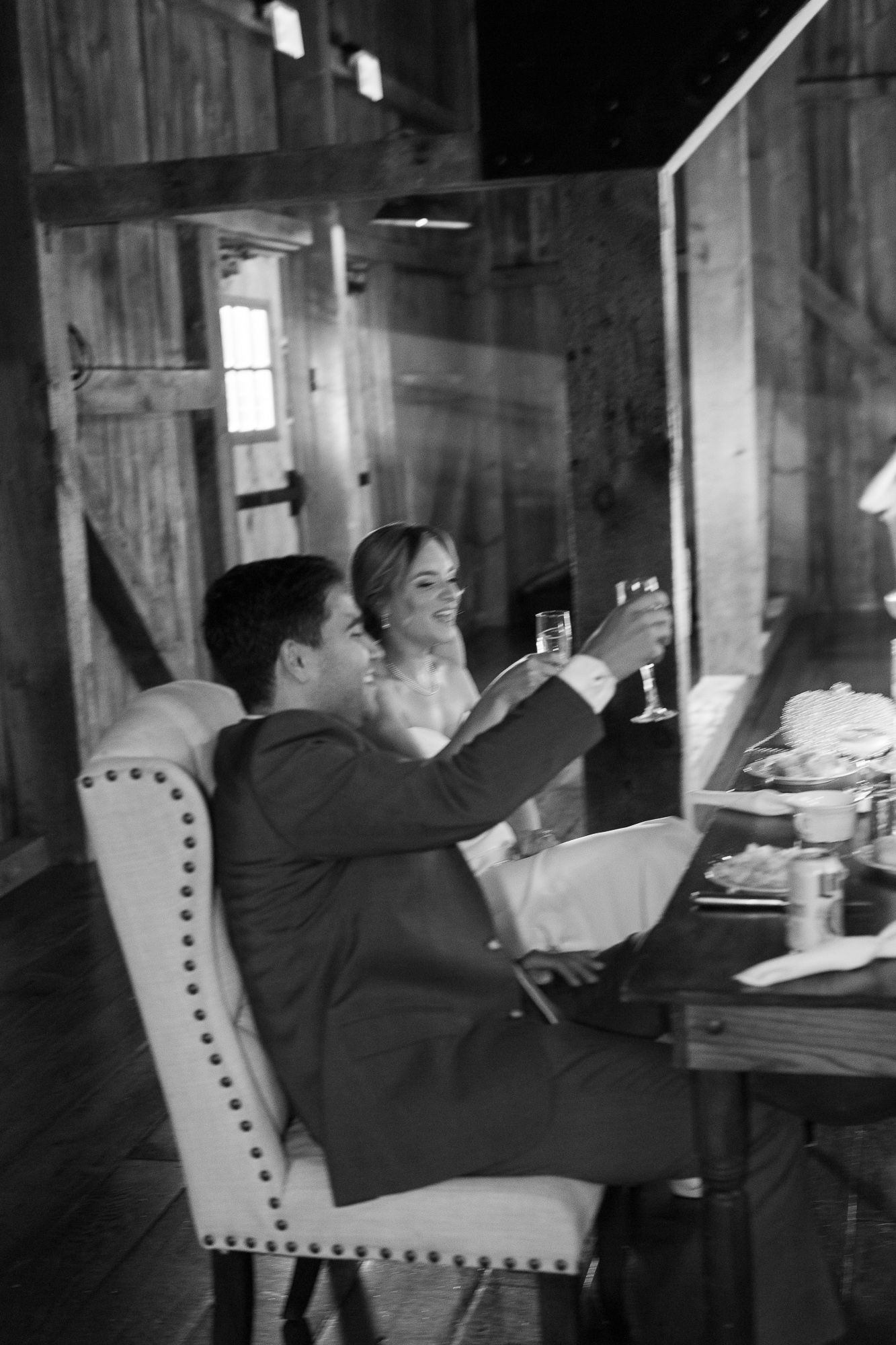 Bride and groom raise their glasses during a toast at a wedding reception in the Barn at the Farm at Eagles Ridge in Lancaster, PA