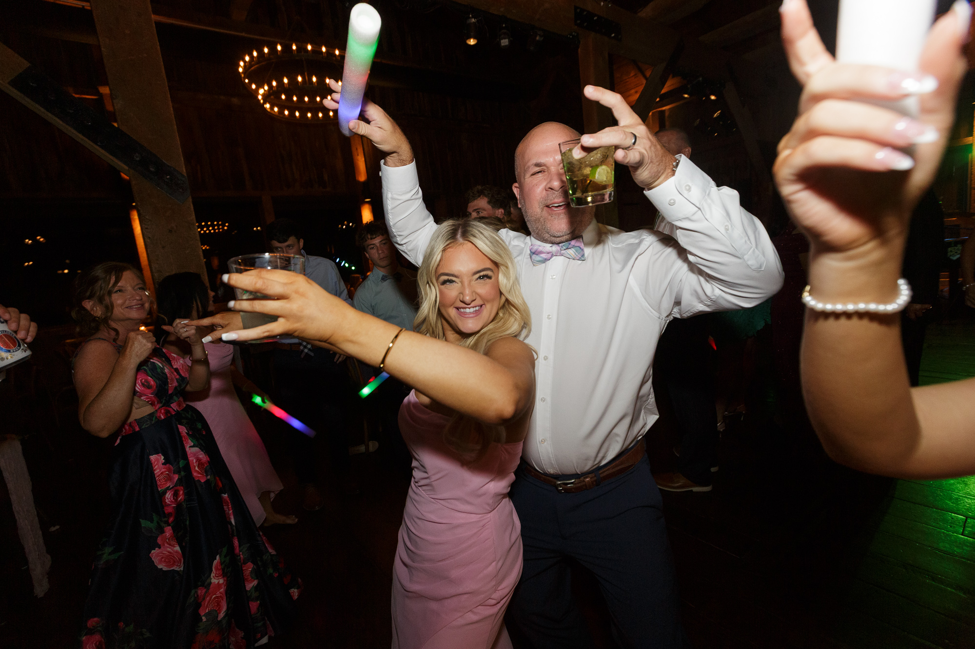 Wedding guests with cocktails in their hands celebrating on the dance floor at Farm at Eagles Ridge in Lancaster, PA