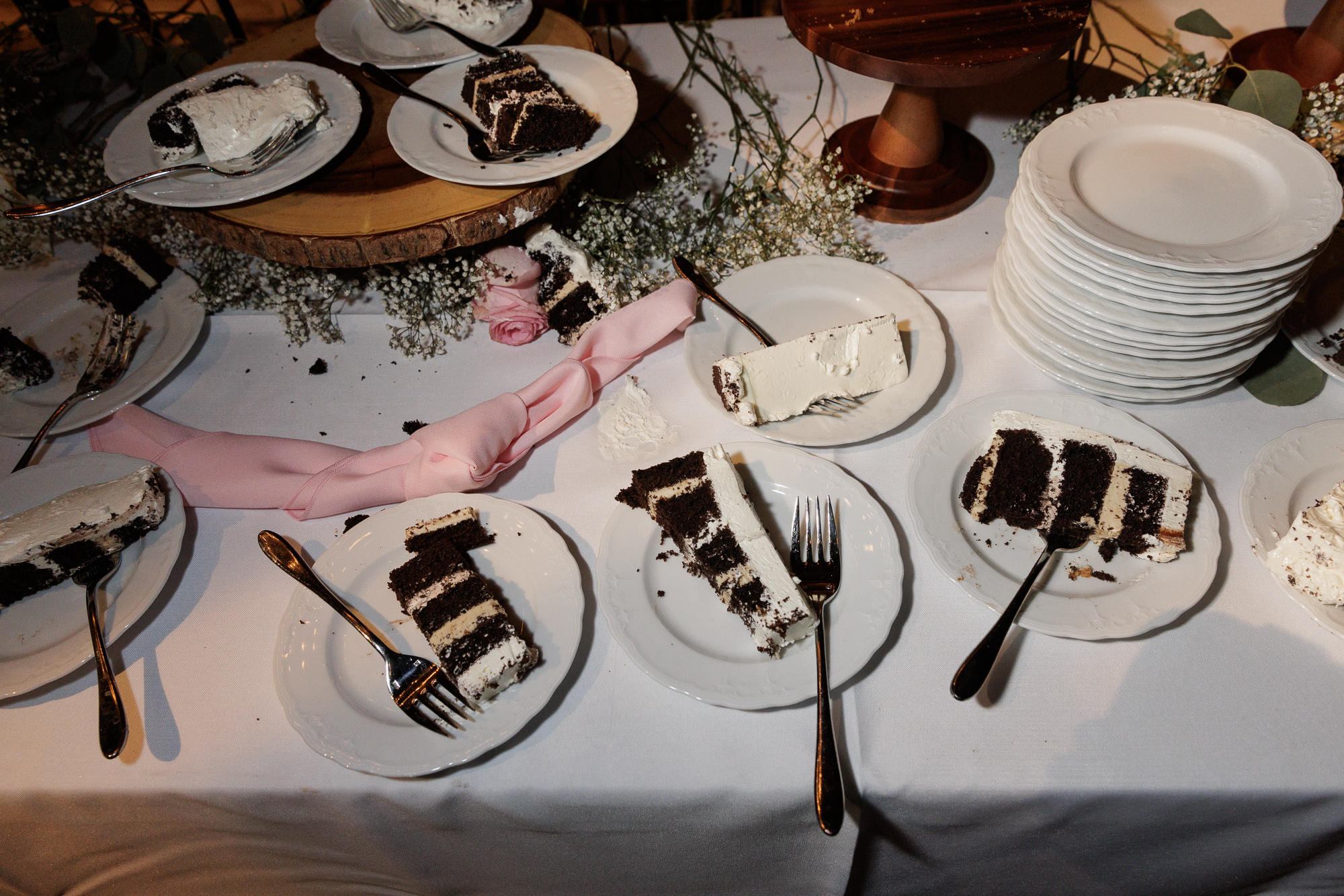 Several plates of tiered chocolate cake on a dessert table at a wedding reception at Farm at Eagles Ridge in Lancaster, PA