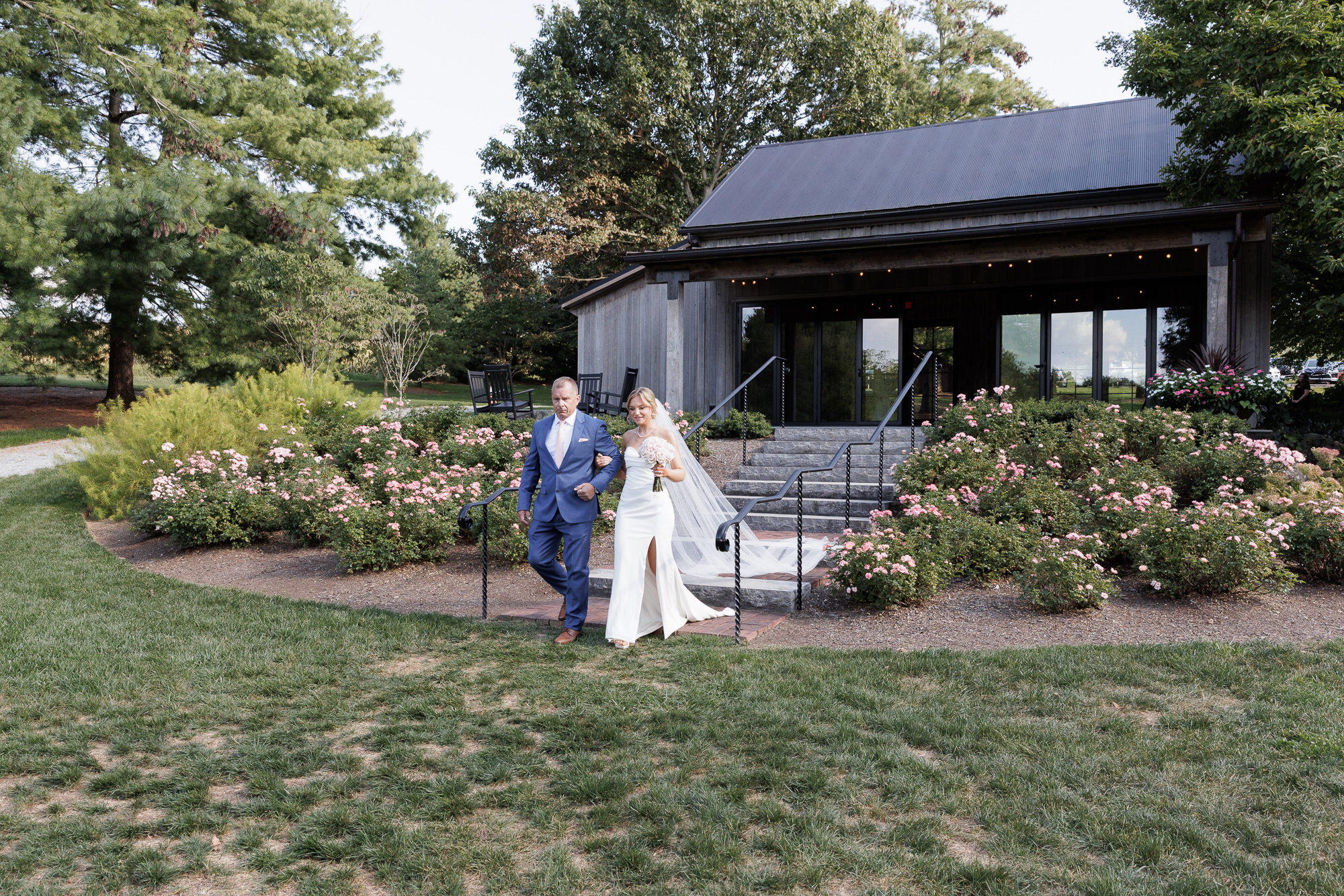 Father and daughter descend steps in front of the Carriage House at Farm at Eagles Ridge