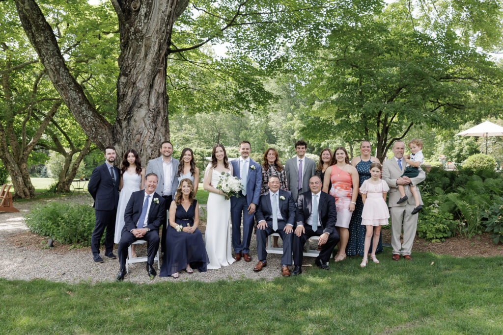An extended family portrait of 18 people taken under the branches of a large shady tree on the Woolverton Inn property