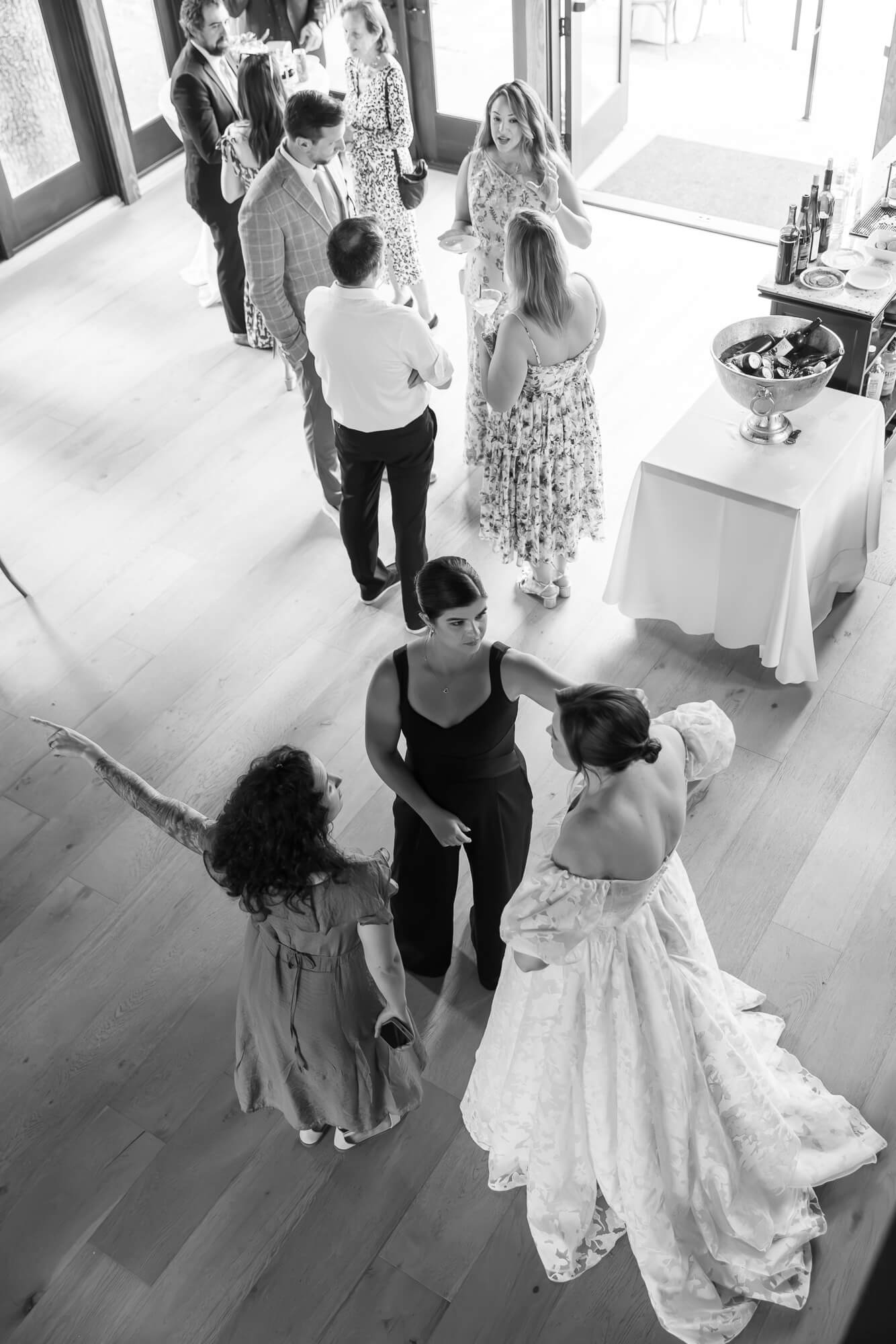 Black and white photo of guests taken from above during a micro wedding cocktail hour in Northridge Barn