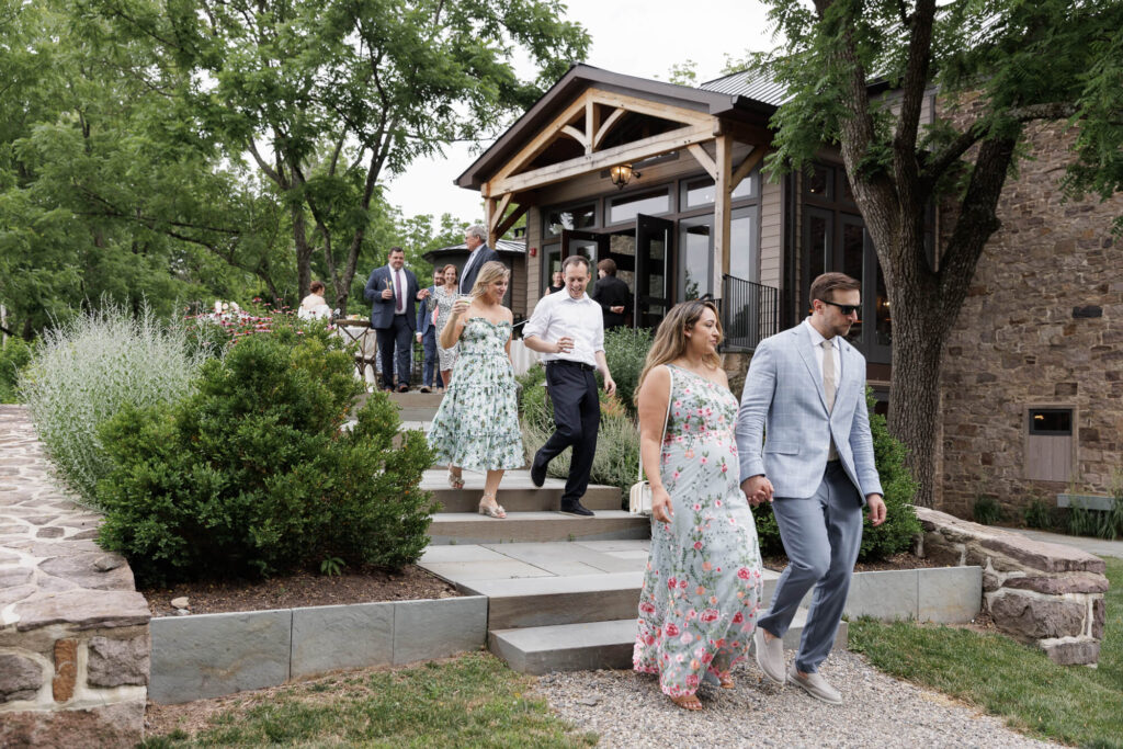 Guests walk down terraced steps from the Northridge Barn toward the patio of the Woolverton Inn