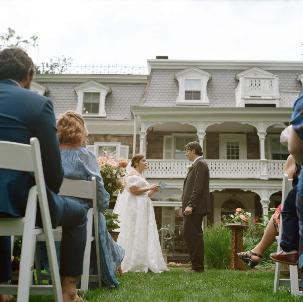Film photograph of a bride and groom saying their vows during a microwedding at the Woolverton Inn