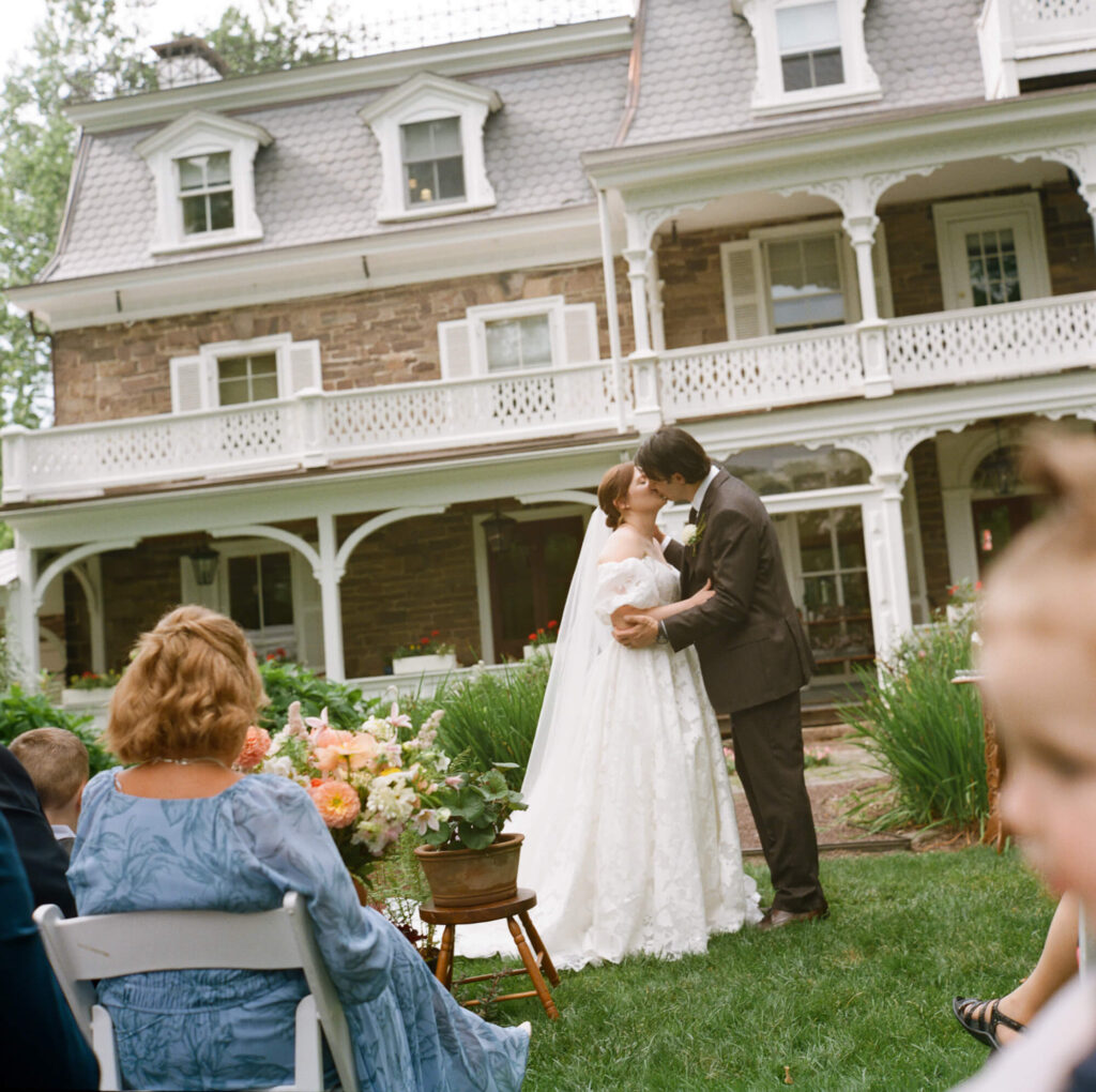Film photograph of a bride and groom kissing after saying their vows at the Woolverton Inn